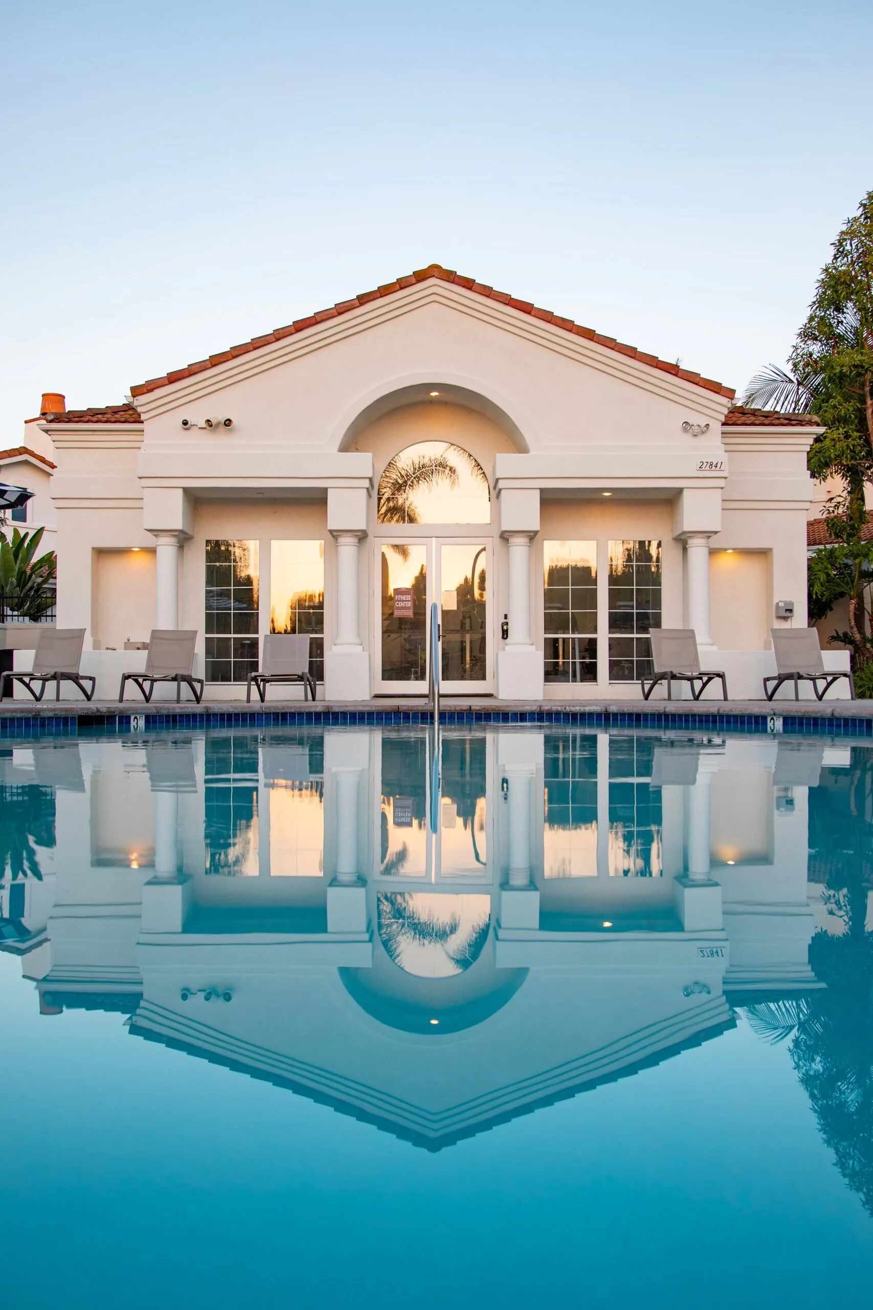 Elegant modern home showcasing a pristine pool at the forefront, epitomizing contemporary luxury and architectural finesse