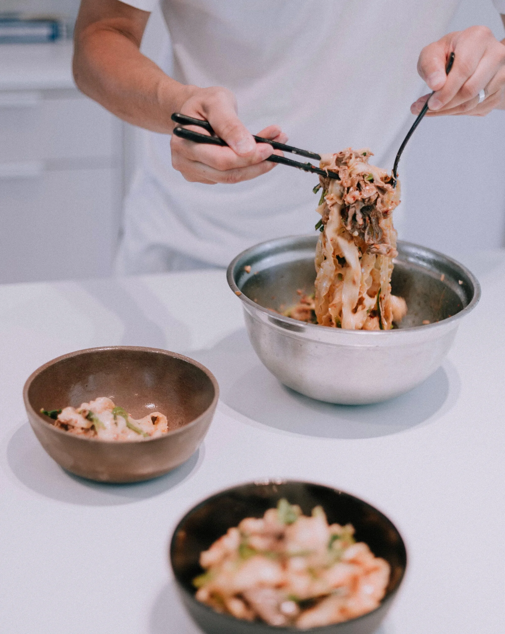 Skilled personal chef artfully preparing an oriental dish in a well equipped kitchen, highlighting culinary expertise and cultural cuisine